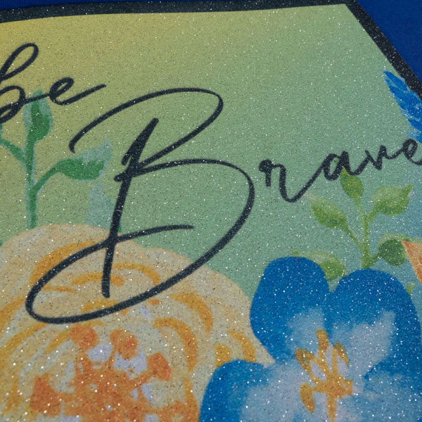 White/Silver GlitterFlex® Ultra Combo sublimated with a design that says "Be brave" with flowers