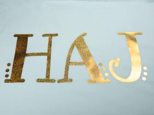 A pillowcase with the initials "HAJ" in Bubble Gold DecoFilm® Soft Metallics