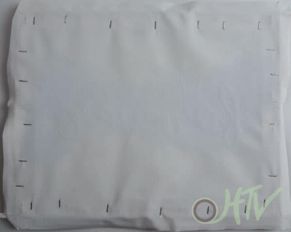 The back of the reverse canvas being stapled into place