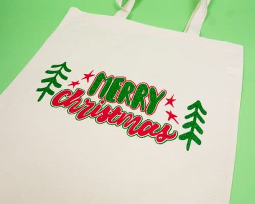 A tote bag with the words "Merry Christmas" from our Christmas Pack Cut File made with Red ThermoFlex® Plus and Green GlitterFlex® Ultra