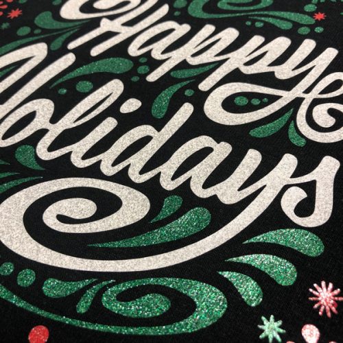 A close up of the word "Happy Holidays" with a fun decorative look. The close up shows the texture of the ThermoFlex® Plus Metal Flake.